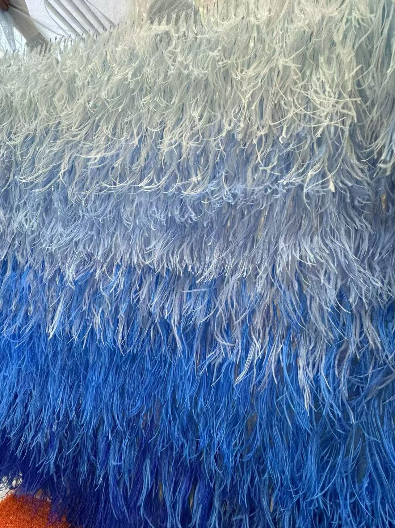 Rows of long feather trims in white, pale blue and deeper blue shades
